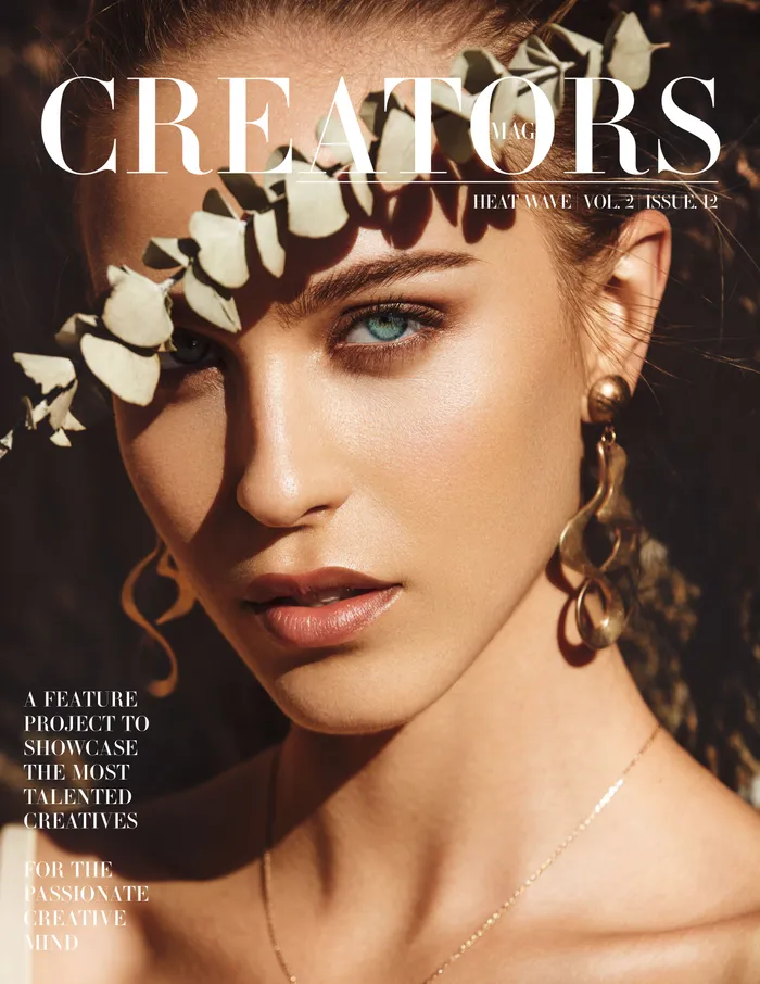 Close-up of a woman's face on 'CREATORS Mag' cover with eucalyptus leaves shadow, highlighting her blue eyes and gold earrings.