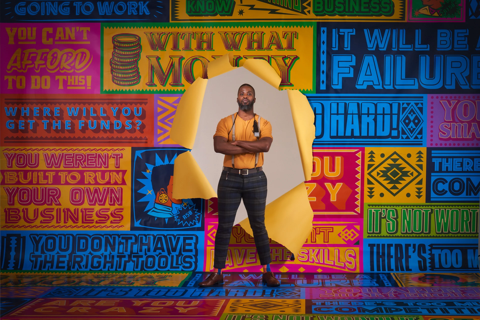 Determined man standing firm amidst a colorful backdrop filled with discouraging business-themed remarks, representing resilience and self-belief.
