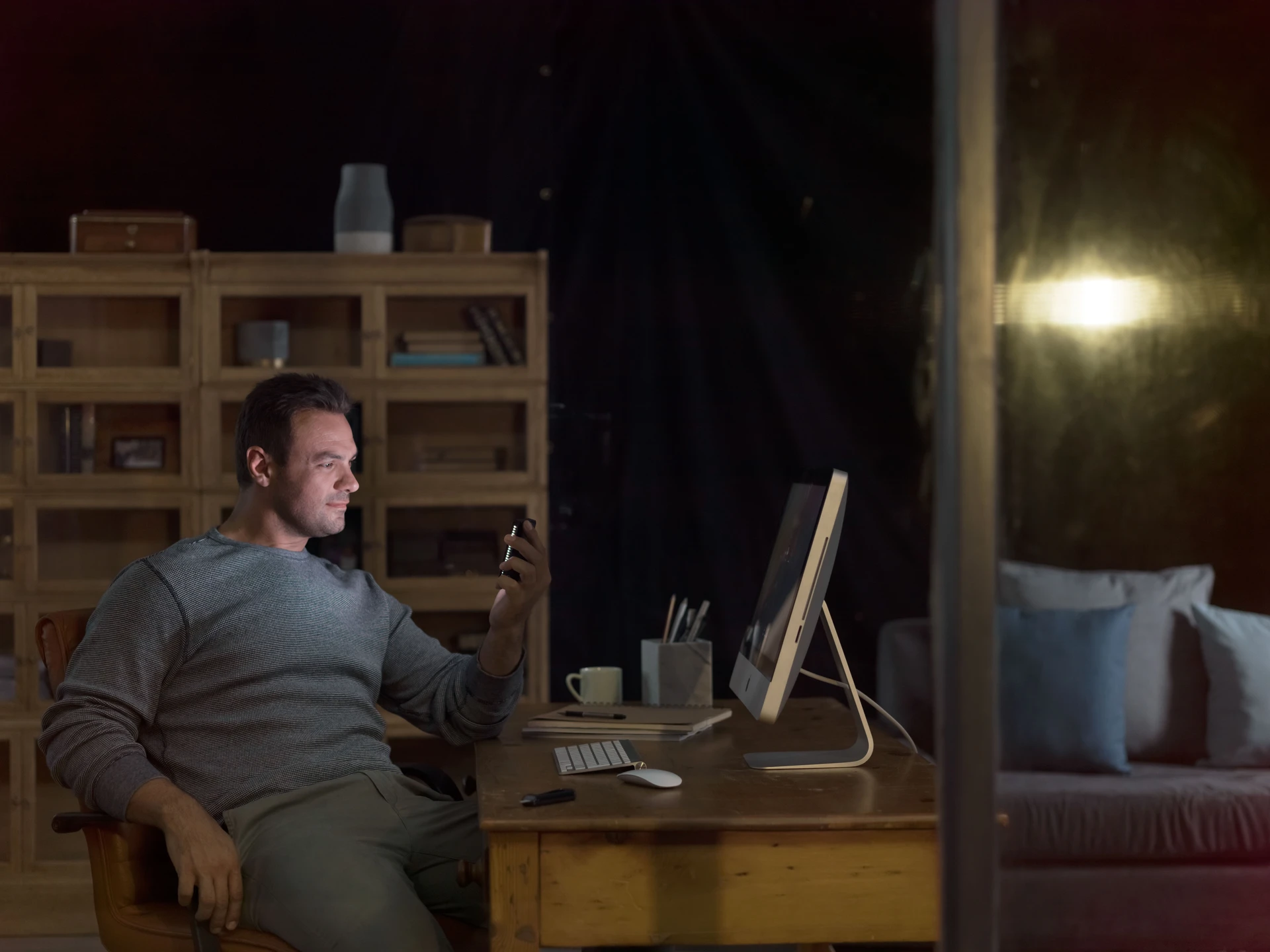 Man checking phone in dimly lit studio room